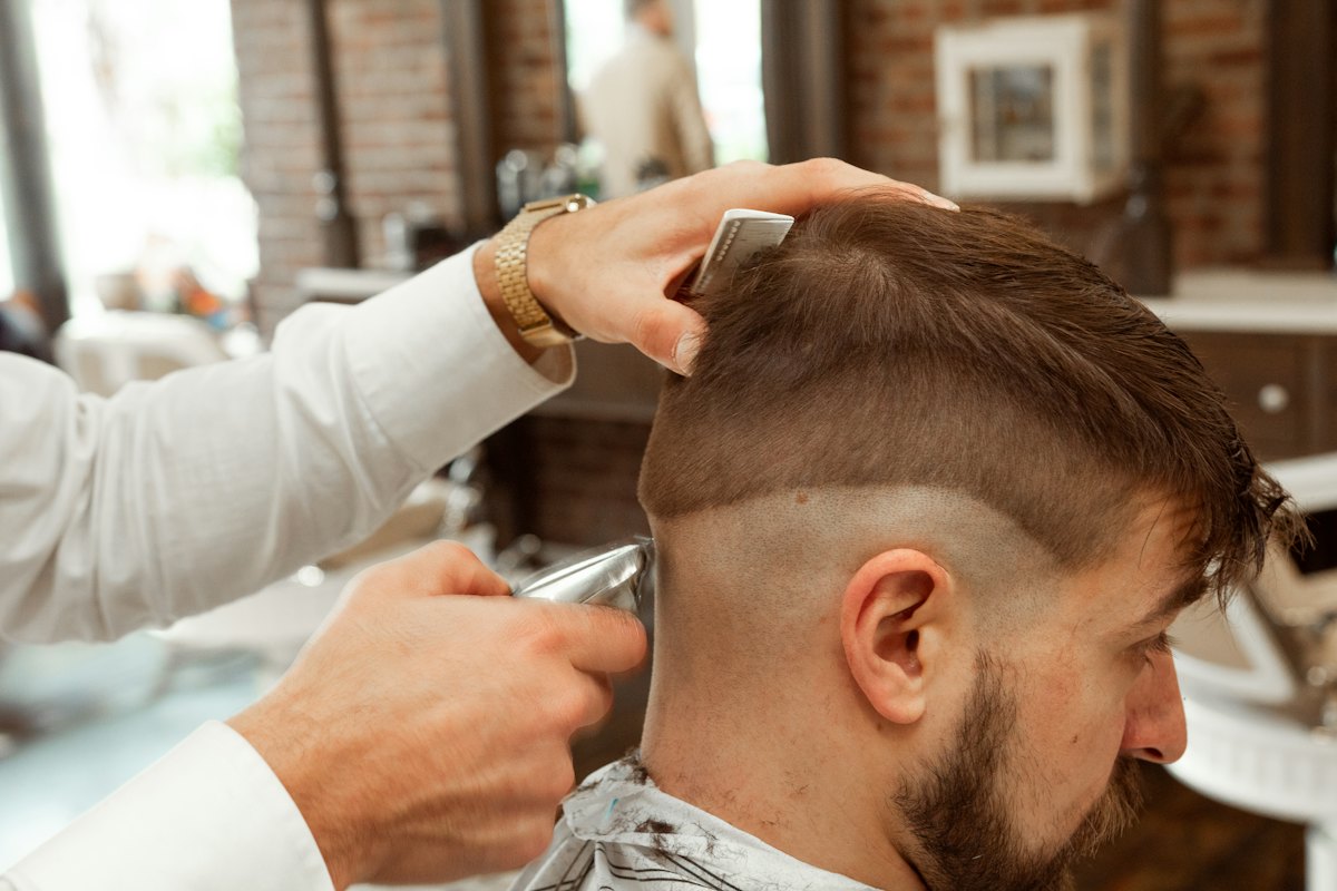 Coiffeur réalisant un dégradé à la tondeuse